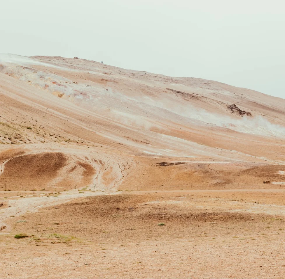dessert hills in sandy browns and a very light blue sky with no clouds