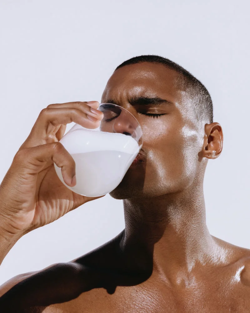 Man drinking from a white cup