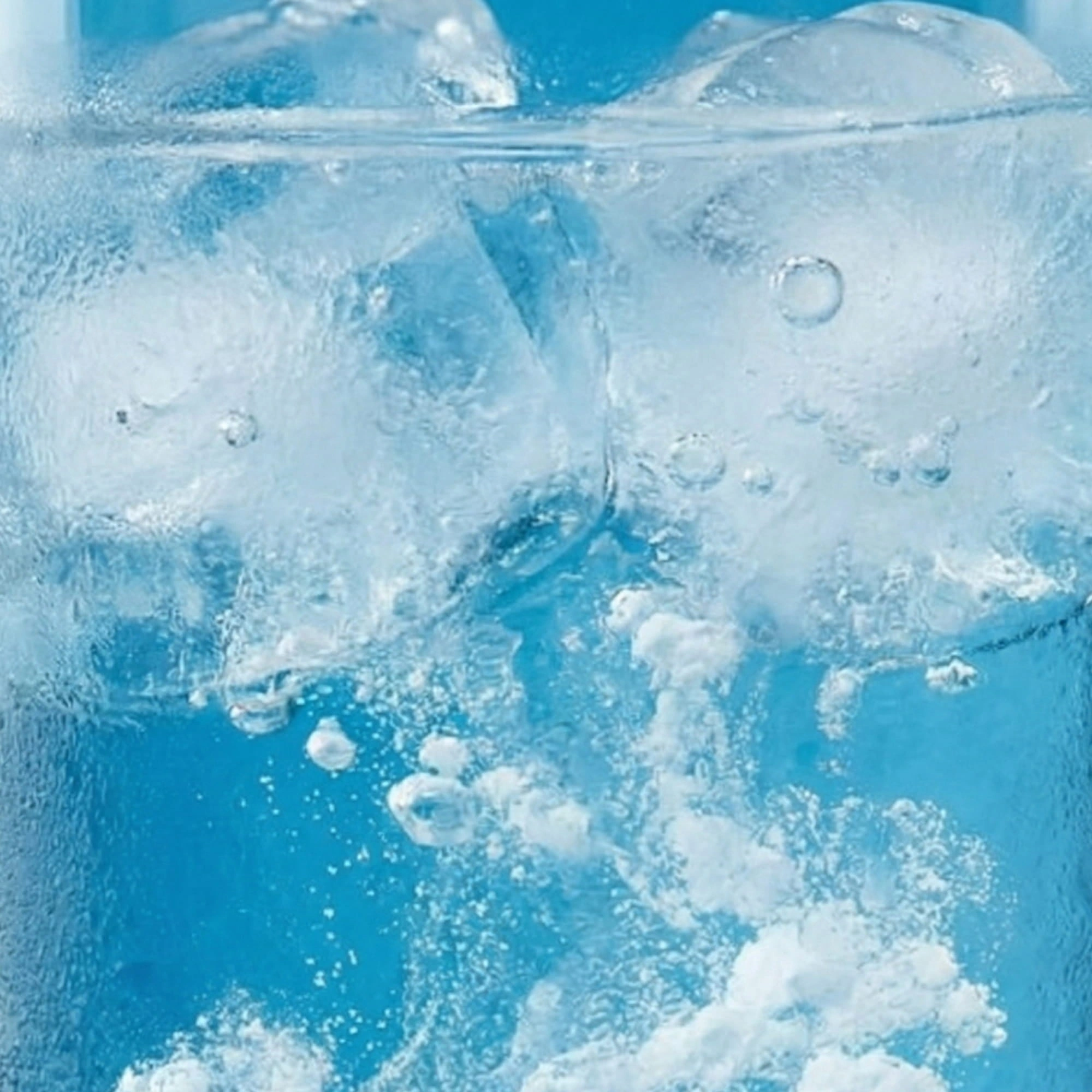 Glass of sparkling water with ice in blue light